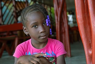 Close-up portrait of young Afro-Surinamese girl with braided hair in the Menimi Eco Resort near Aurora