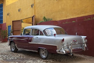 Pastel coloured house and old 1950s vintage American Chevrolet Bel Air car