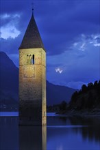 The submerged church tower at night in Lago di Resia at Curon Venosta