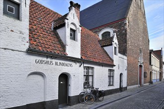 Almshouse Blindekens and chapel along cobbled alley in Bruges