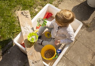 Subject: Child playing in a sandbox.
