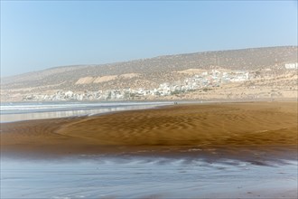 Sandy beach at low tide near village of Taghazout