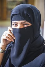 Veiled woman in the bazaar Souk Al-Mubarakiya