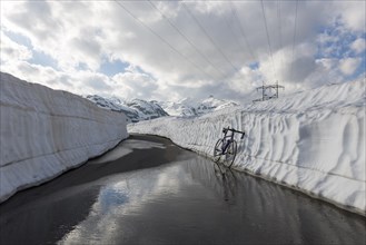 Bicycle leaning on a snow wall on the mountain pass San Gottardo