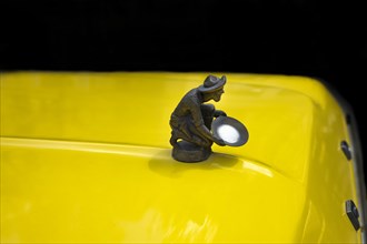 Gold washer as radiator mascot on an older Ford Pick Up