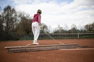 Subject: Woman aged 82 standing on the tennis court.