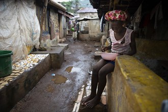 Girl with a plate living in Bomeh Village at the KissyRoad dumpsite