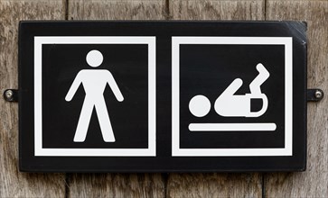 Male toilet sign with baby nappy diaper changing facility