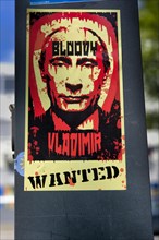 Sticker on a light pole with Putin as Bloody Vladimir who is wanted