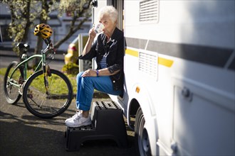 Subject: Pensioner in front of her caravan.