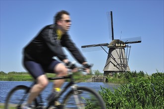 Cyclist and thatched windmill at Kinderdijk