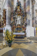 Side altar with floral decoration and annual candle