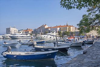 Small fishing boats and motor yachts in marina north of the Old Town city walls of Budva along the Adriatic Sea