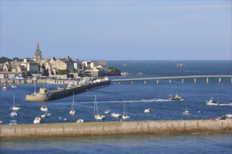 The church Notre-Dame de Croaz Batz and sailing boats and fishing boats in the harbour of Roscoff