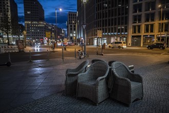 Unused furniture standing in front of a cafe at Potsdamer Platz in Berlin in the evening