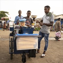 Street vendor selling baguette eggs and coffee at a market in Lome