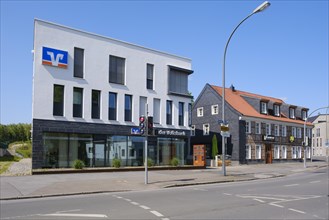 Modern commercial building next to half-timbered house