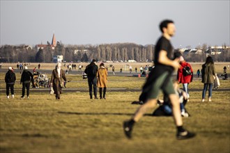 People stand out on Tempelhofer Feld in spring weather in Berlin