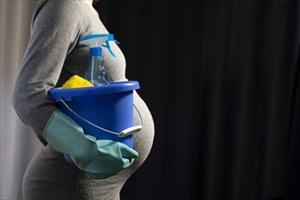 Pregnant woman with cleaning bucket