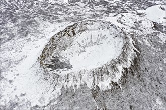 Aerial view over the Eldborg volcanic crater in the Eldborgarhaun lava field covered in snow in winter