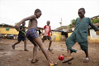 Children play football in Bomeh Village at the KissyRoad dumpsite