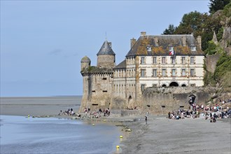 Tourists on beach in front of the Mont Saint-Michel abbey