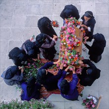 Women decorate an epitaph with flowers on Good Friday