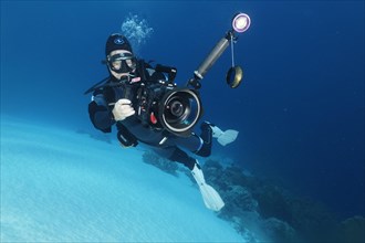 Cameraman with professional underwater video camera type RED Dragon X 6K Digital Cinema Camera in Nauticam underwater housing