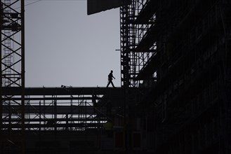 The silhouette of a scaffolder stands out on a construction site in Berlin