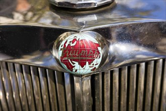 Logo with world map and lettering Triumph from the historic classic sports car vintage 1948
