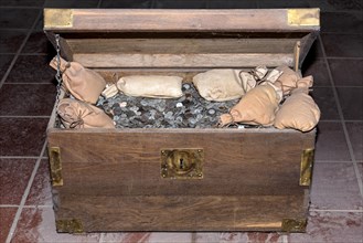 Wooden chest filled with coins and money bags