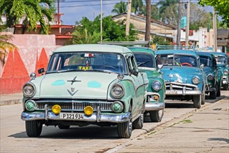 Parked American classic cars used as Cuban taxis in the town Jatibonico