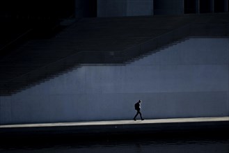 A man stands out in the sunshine at the Spreebogen in the government district in Berlin
