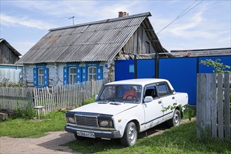 Traditional wooden house with white car