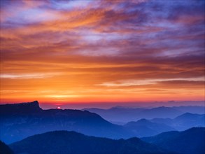 Alpine panorama at sunrise with red clouds