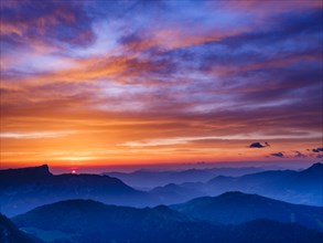 Alpine panorama at sunrise with red clouds