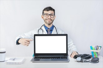 Smiling doctor pointing at an advertisement on the laptop screen