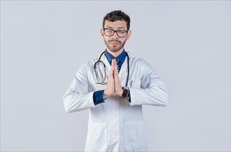 Doctor praying with hands together on isolated background