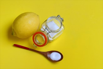 Citric acid in wooden spoon and glass container