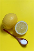 Citric acid in wooden spoon and lemon