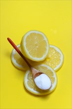 Citric acid in wooden spoon and lemon