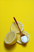 Citric acid in wooden spoon and lemon