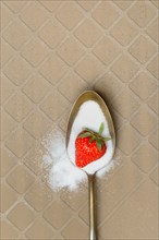 Spoon with sugar and strawberry