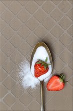 Spoon with sugar and strawberries