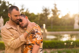 Homosexual couple embracing at sunset in a park in the city