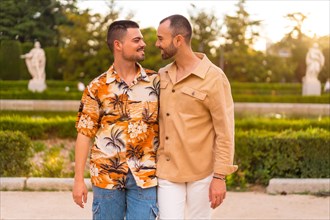 Romantic portrait of gay newlyweds walking and having fun at sunset in a park in the city