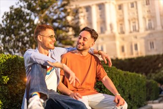 Portrait of gay newlyweds sitting in the park at sunset in a park in the city