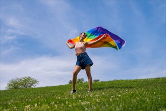 Caucasian brunette woman with a rainbow lgbt flag