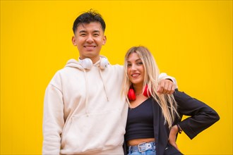 Portrait of a multiethnic couple of Asian man and Caucasian woman on a yellow background