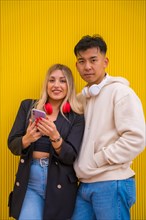 Portrait of multiethnic couple of Asian man and Caucasian woman on a yellow background